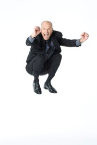 Businessman jumping into the air and looking excited